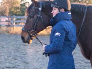 Woman wearing a Kyla jacket standing next to horse