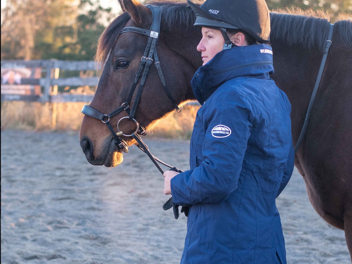 Woman wearing a Kyla jacket standing next to horse